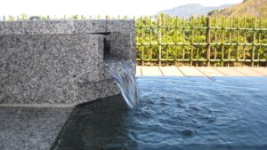 石造りの露天風呂に水が流れ込む様子