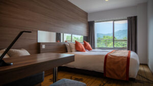 Lits jumeaux près d’une fenêtre avec vue sur la montagne