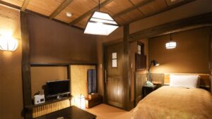 Letto in una camera tradizionale di ryokan con televisione