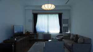 Zona de estar con sofá, sillones, escritorio y televisión