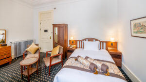 Cama individual con sillas y mesa pequeña en la habitación