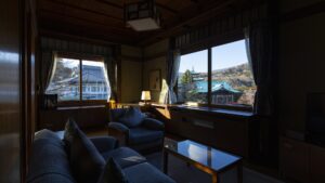 Zona de estar con sofá junto a las ventanas de la habitación