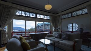 Zona de estar con sofá junto a grandes ventanales en la habitación