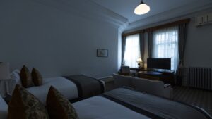 Camas individuales y zona de estar junto a las ventanas