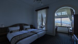 Dos camas individuales junto a la ventana con vistas a las montañas