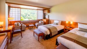 Camas individuales en una habitación con asientos junto a la ventana