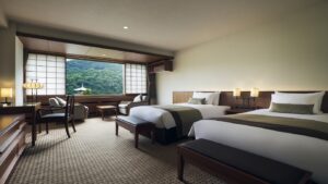 Camas individuales en una habitación con asiento junto a la ventana