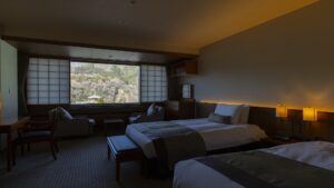 Dos camas individuales en una habitación con zona de estar junto a la ventana