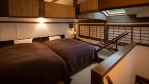 Due letti accanto a pannelli shoji in una camera mansardata