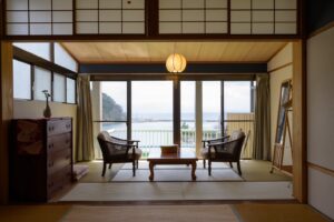 Camera con tatami, sedie e balcone con vista sull’oceano