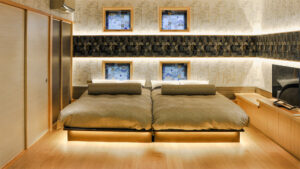 조명이 비치는 헤드보드 벽의 트윈 침대