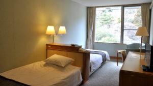 객실 창가 옆에 놓인 싱글 침대 2개