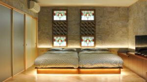 은은한 조명의 객실에 놓인 트윈 침대 2개