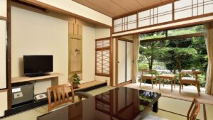 Tatami room with low table and chairs by garden.