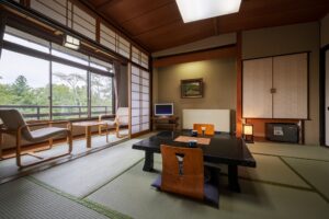 Habitación de tatami con mesa baja y sillas junto a la ventana