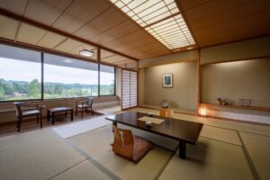 Habitación de tatami con mesa baja y asientos junto a la ventana