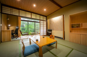 Habitación de tatami con mesa baja y zona de estar junto a la ventana