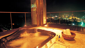 Bagno all'aperto su un balcone con vista sulle luci della città di notte