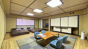 Camera in tatami con tavolo basso e due letti