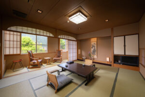 低いテーブルと窓際の椅子がある畳の部屋