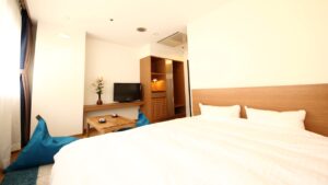 テレビとビーズクッションのある客室の大型ベッド