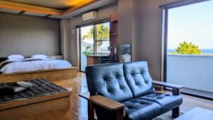Chambre avec canapé, lit et fenêtre avec vue sur l’océan