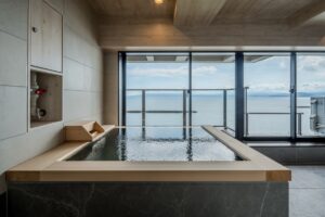 Bain intérieur privé avec vue sur l’océan à travers des portes vitrées