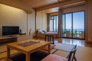 Chambre en tatami avec table basse et chaises près des fenêtres