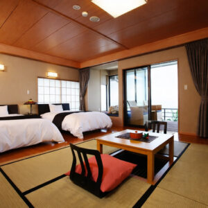 Chambre en tatami avec table basse, chaises et lits jumeaux
