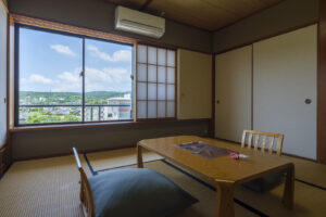 Chambre en tatami avec table basse, coussins de sol et fenêtre