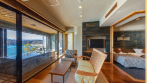 Habitación con zona de estar junto a la cama y vistas al balcón