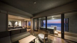 Habitación con sofá y baño al aire libre frente al océano