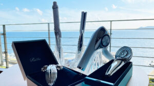 Secador de pelo y herramientas de peinado sobre una mesa junto al mar