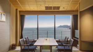 Vista al océano desde una habitación de tatami con mesa y sillas