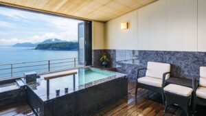 Baño privado junto a una ventana abierta con vistas al océano