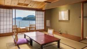Habitación de tatami con mesa baja y sillas junto a la ventana