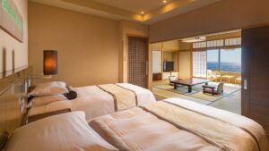 Habitación con dos camas individuales, zona de estar de tatami y vista al mar