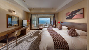 Habitación con dos camas individuales frente a un balcón con vistas al mar