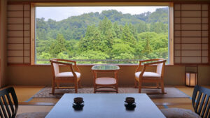 Vista al bosque desde una habitación de tatami con sillas y mesa