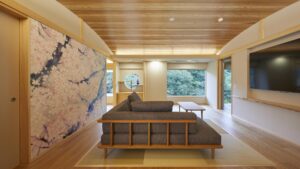 Zona de estar con tatami, sofá, mesa y TV de pared