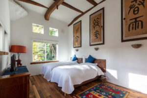 明亮客房内的两张床，带木梁