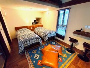 客房内两张配有橙色靠垫的床