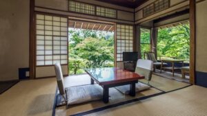 Habitación de tatami con mesa baja y sillas junto a la ventana