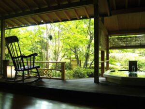 Open-air bath beside a wooden deck and rocking chair