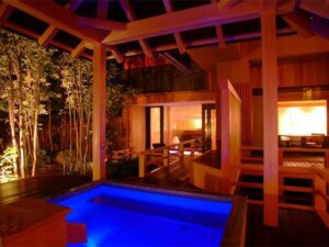 Private open-air bath on wooden terrace at night