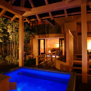 Private outdoor bath beside a wooden ryokan room