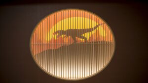 Round decorative window with dinosaur silhouette artwork