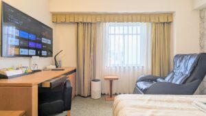 Letto, scrivania e poltrona reclinabile vicino alla finestra