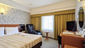 Camera con letto, poltrona, scrivania e finestra