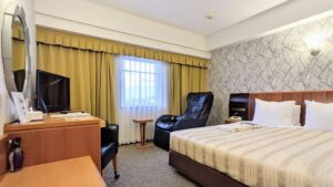 Camera con letto matrimoniale, scrivania, sedia e finestra